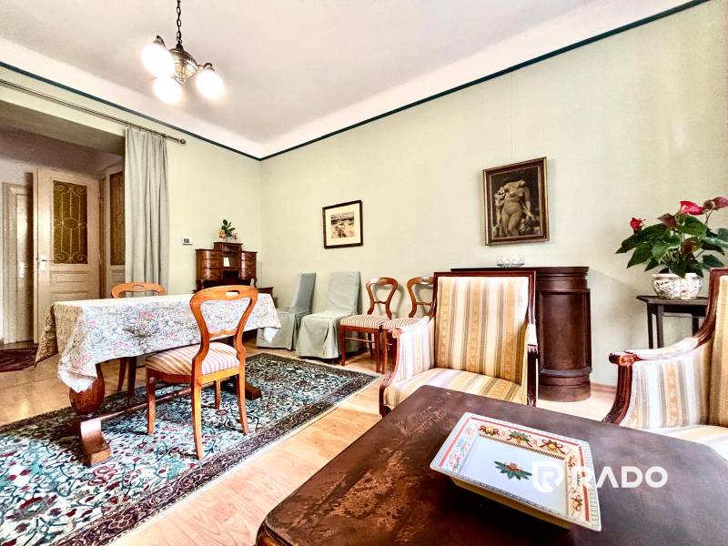 Living room in a two-room apartment with wooden furniture and a colorful carpet.