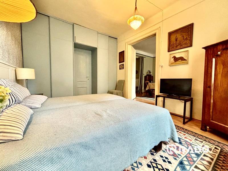 A bedroom in a 2-room apartment with a double bed and antique furniture.