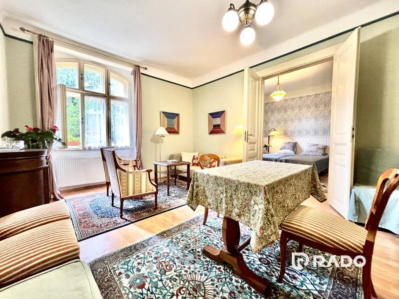 Traditional interior of a 2-room apartment with carpet, furniture, and houseplants.