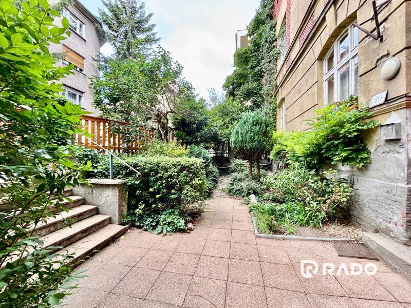A small garden with greenery next to a residential building on Flöglova Street in Bratislava - Staré Mesto.