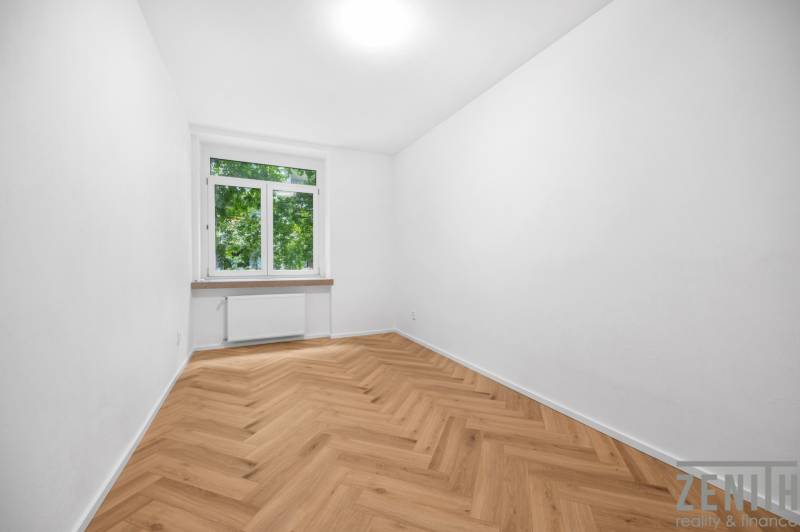 A room in a 3-room apartment with a parquet floor and a large window, light decoration.