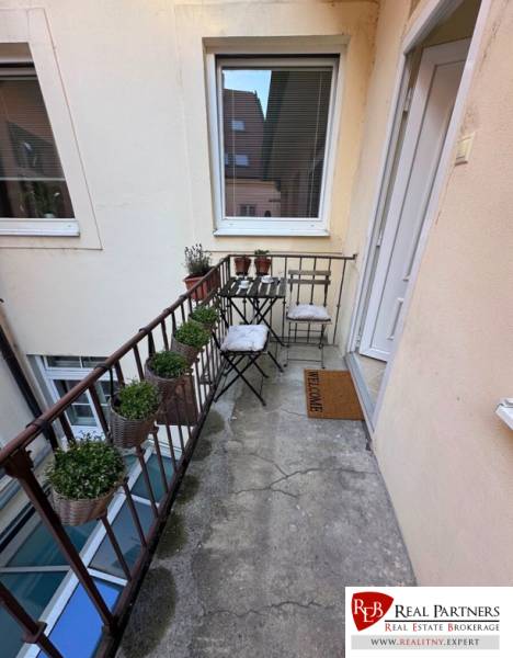 Balcony on Ventúrska in Bratislava at a 2-room apartment with plants and chairs.