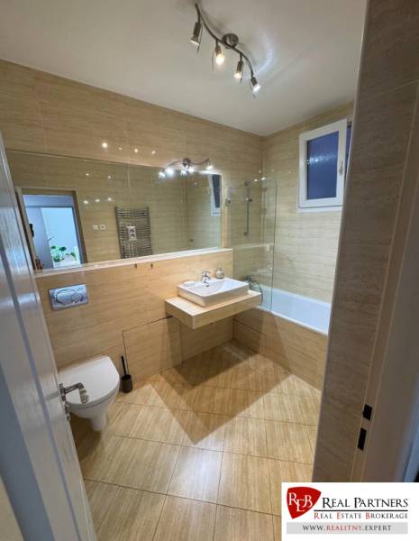 Bathroom in a 2-room apartment with a sink, bathtub, and toilet.