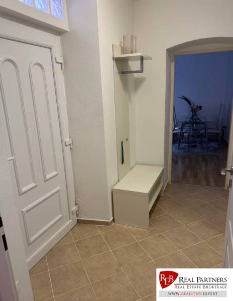 Entrance hallway of a 2-room apartment with white furniture and tiles.