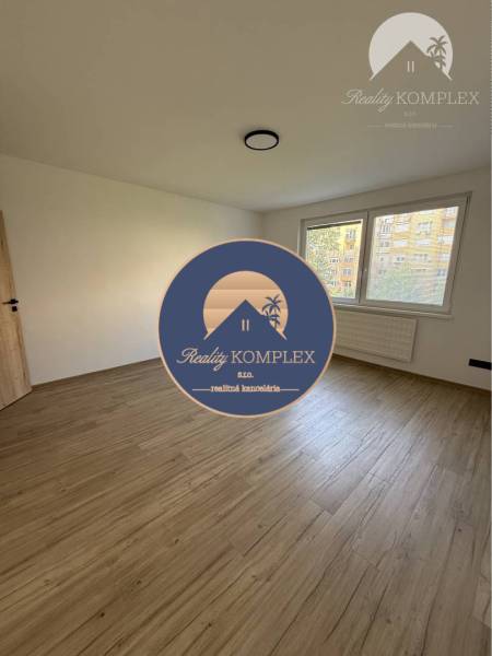 A room with a wooden floor and a large window in a 3-room apartment.