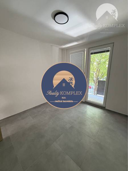 A room with large windows and light tiles in a 3-room apartment.