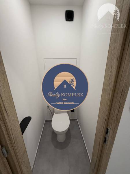 Toilet in a 3-room apartment with white walls and wooden doors.