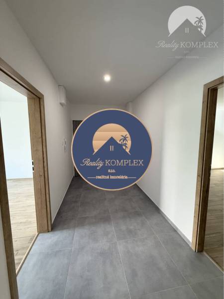 A hallway in a 3-room apartment with a gray floor and entrances to the rooms.