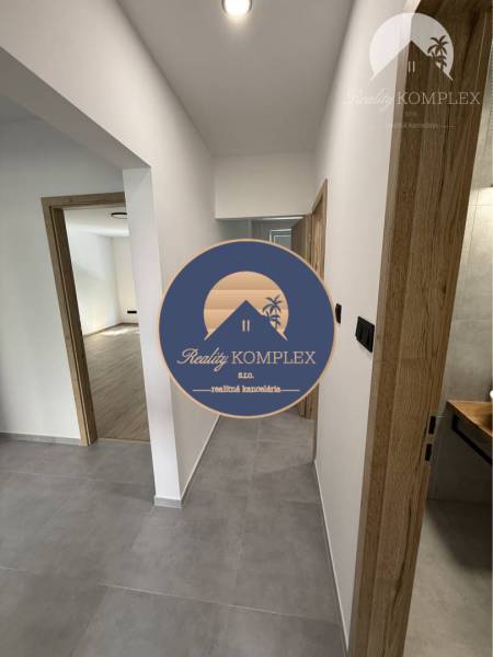 A hallway in a 3-room apartment with wooden doors and ceramic tiles.