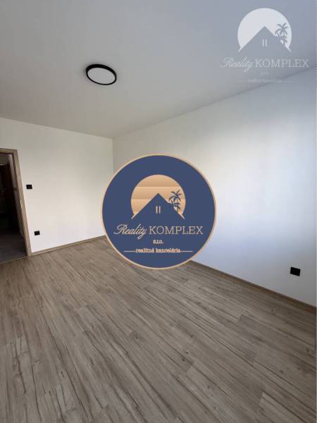 A room with a wooden floor and white walls in a 3-room apartment.