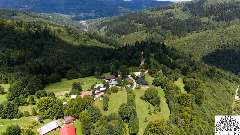 Aerial view of wooded recreational lands in Oščadnica with rural buildings.