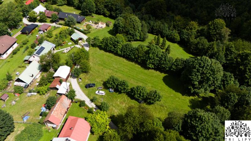 Aerial view of recreational plots in Oščadnica surrounded by greenery and buildings.
