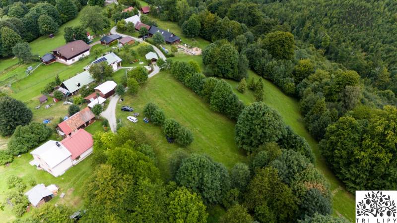 Aerial view of recreational plots in Oščadnica, surrounded by forests and houses.