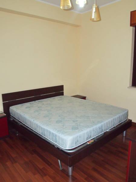 Bedroom in a 3-room apartment with a double bed and wooden flooring.