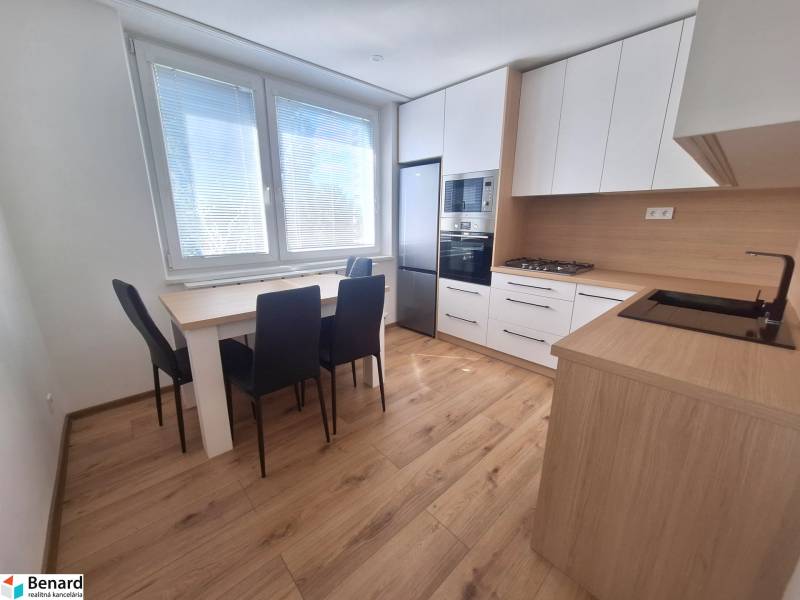 Kitchen in a 2-room apartment with a dining table, stove, and appliances.