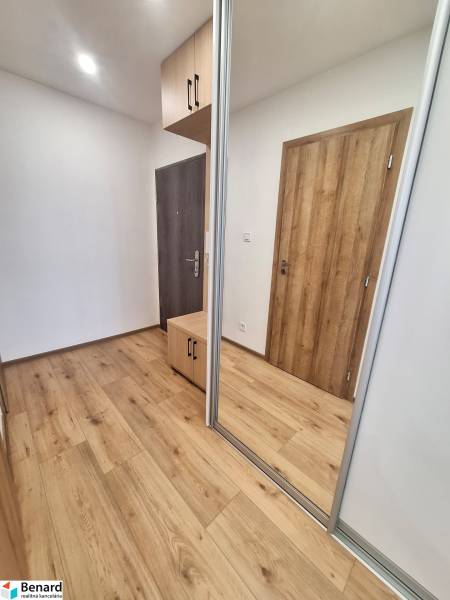 Entrance hall in a 2-room apartment with wooden floors and a mirrored wardrobe.