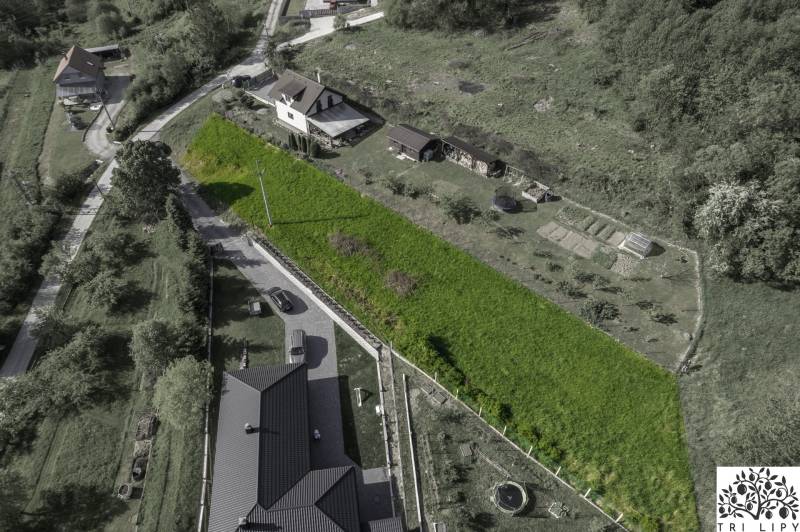 Aerial view of residential plots in Raková, surrounded by greenery and houses.