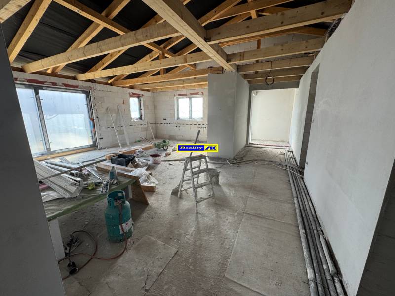 Construction in a family house with exposed beams and building materials on the floor.