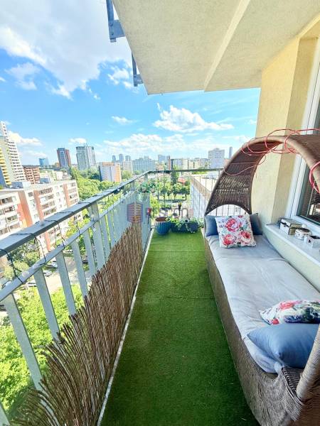 A balcony with artificial grass and garden furniture in a 2-room apartment with a view of Bratislava.