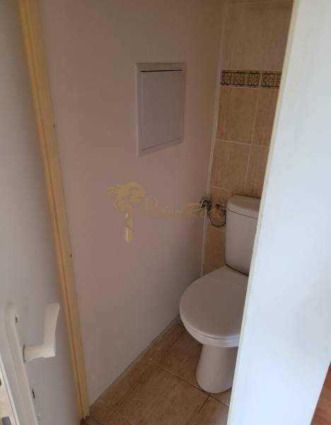 A toilet with tiles and entrance doors in a 3-room apartment.