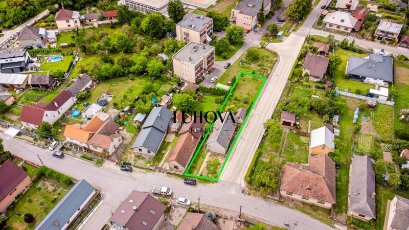 Aerial photograph of Pavla Koyša Street in Ladce, depicting family houses and surrounding gardens.