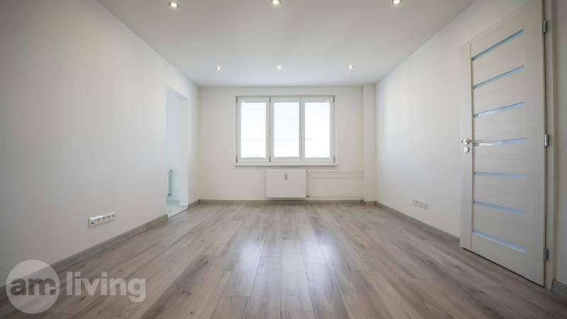 A bright room in a 2-room apartment with a window and a floor with a wooden decor.