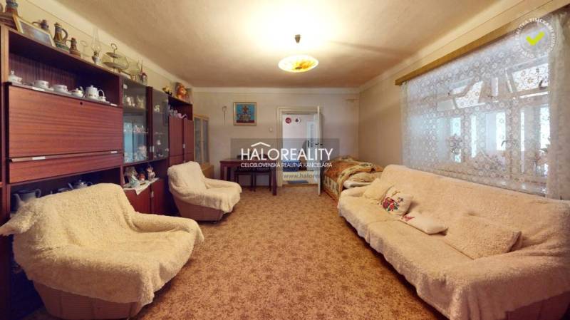 Room in a cottage with a blue carpet, wardrobe, chandelier, wooden floor.