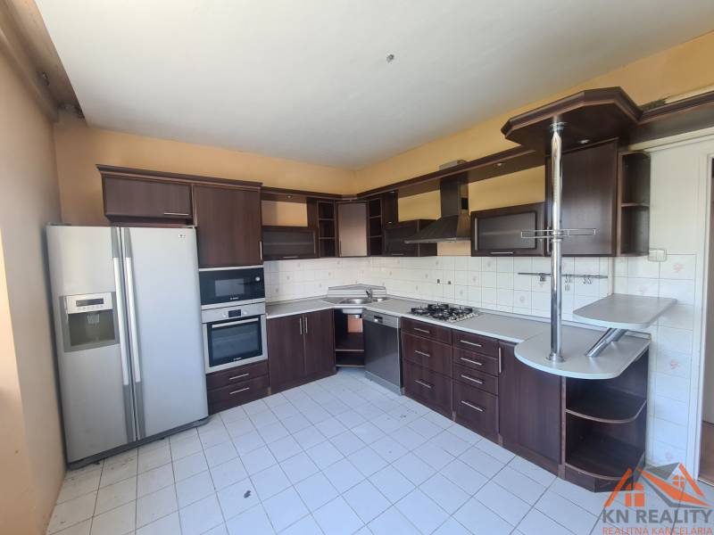 A family house kitchen with built-in appliances and a dining counter.