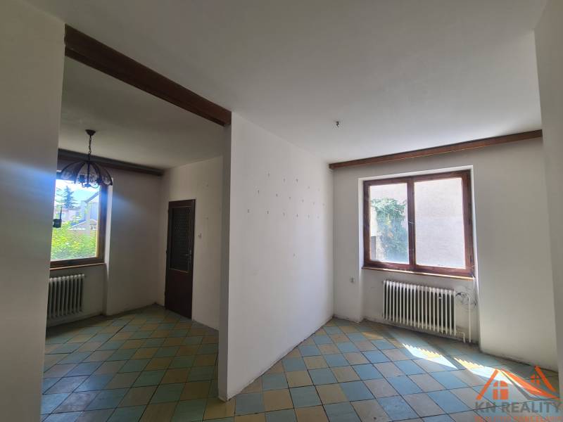 The interior of a family house with a tiled floor and a wooden beam on the ceiling.
