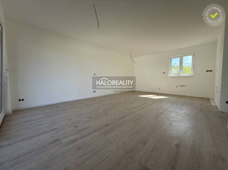 A spacious room in a family house with wooden flooring and white walls.