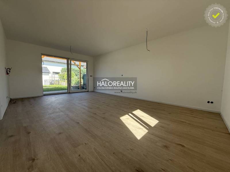 A spacious living room with wooden flooring in a family house.