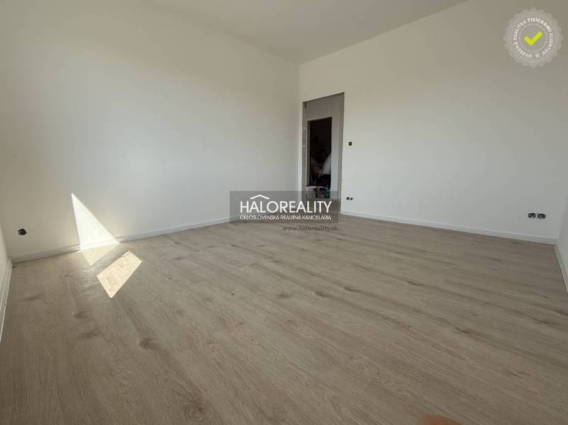 An empty room in a family house with wooden flooring and white walls.