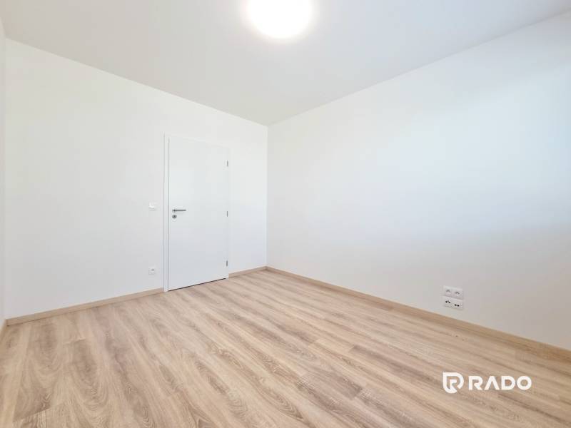 A room with a light floor and white walls in a 3-room apartment.