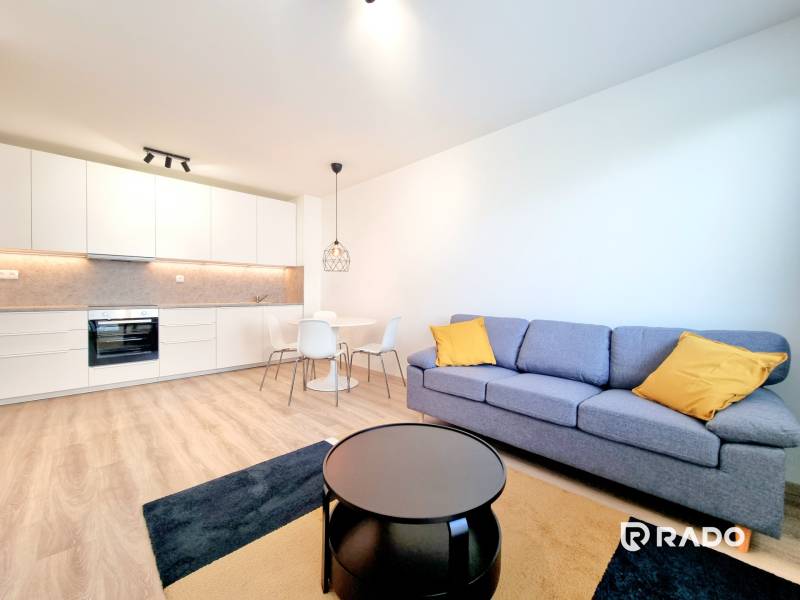 A bright kitchen with a living room and a sofa in a 3-room apartment.