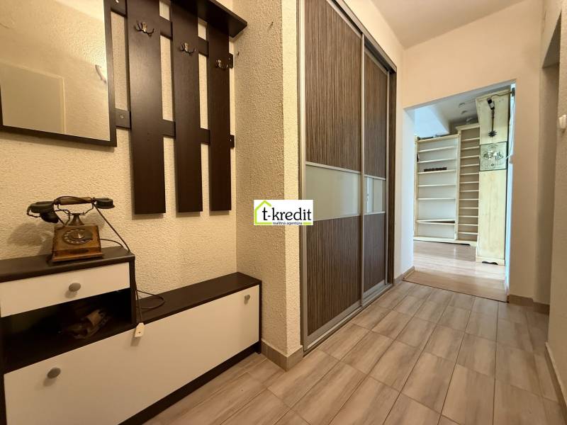 Hallway of a 2-room apartment with a coat rack and an antique telephone.