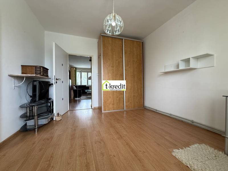 Interior of a 2-room apartment with wooden flooring, built-in wardrobe, and TV stand.