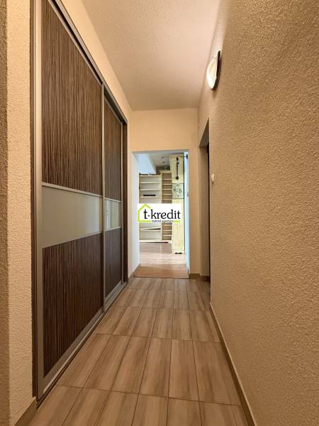 A hallway with a wooden floor and a built-in wardrobe in a 2-room apartment.