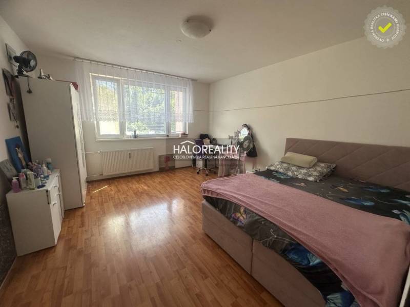 A bright bedroom with wooden flooring and a large window in a 3-room apartment.