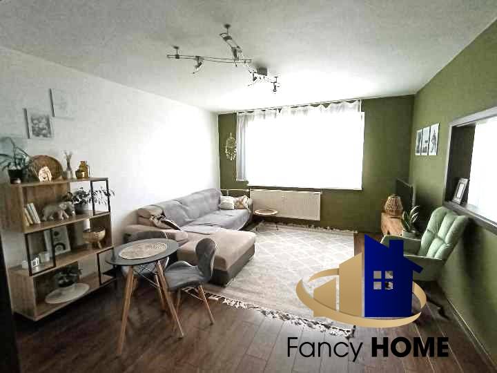 Living room in a 3-room apartment with a sofa, an armchair, and a bookshelf.