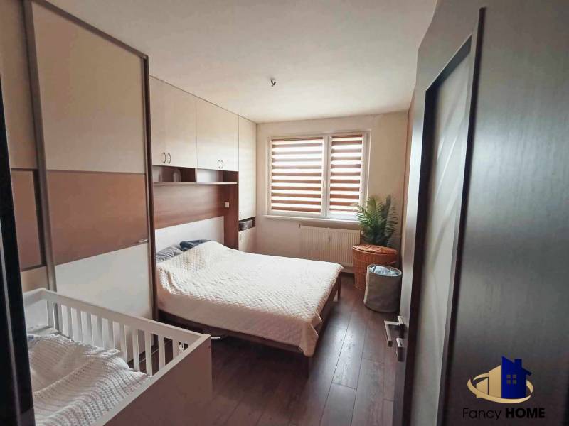 Bedroom in a 3-room apartment with a bed, a baby crib, and a wardrobe.