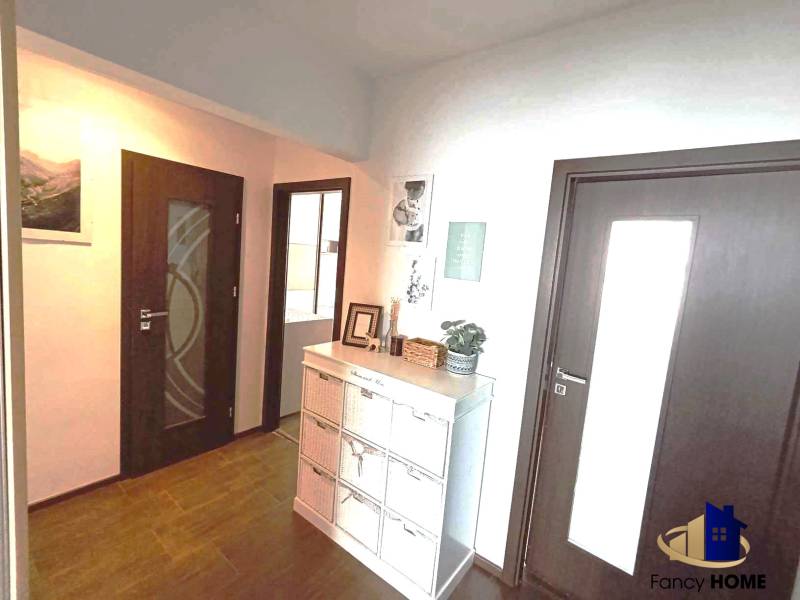 A hallway in a 3-room apartment with wooden doors and storage space.