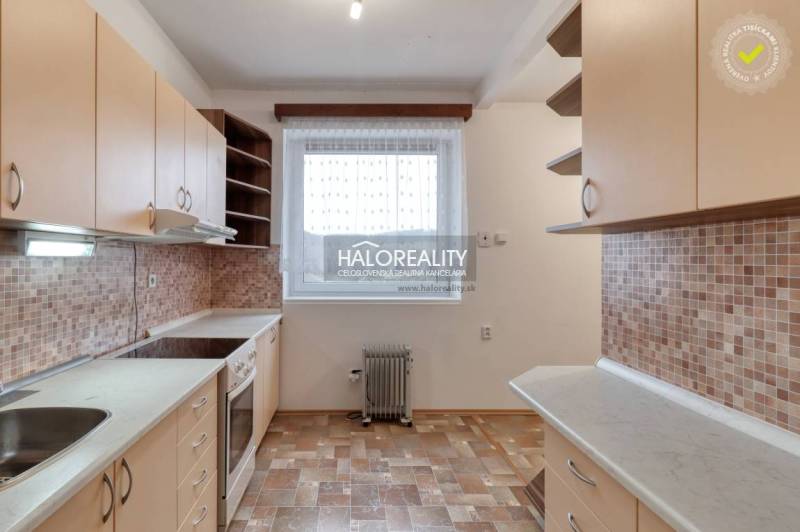 A kitchen in a 3-room apartment with a window, a countertop, and ceramic tiles.