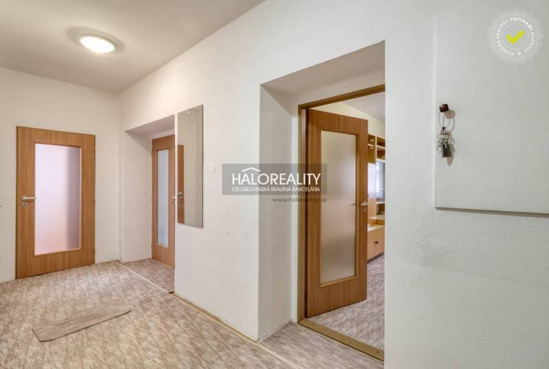 Hallway of a 3-room apartment with wooden doors and a mirror.