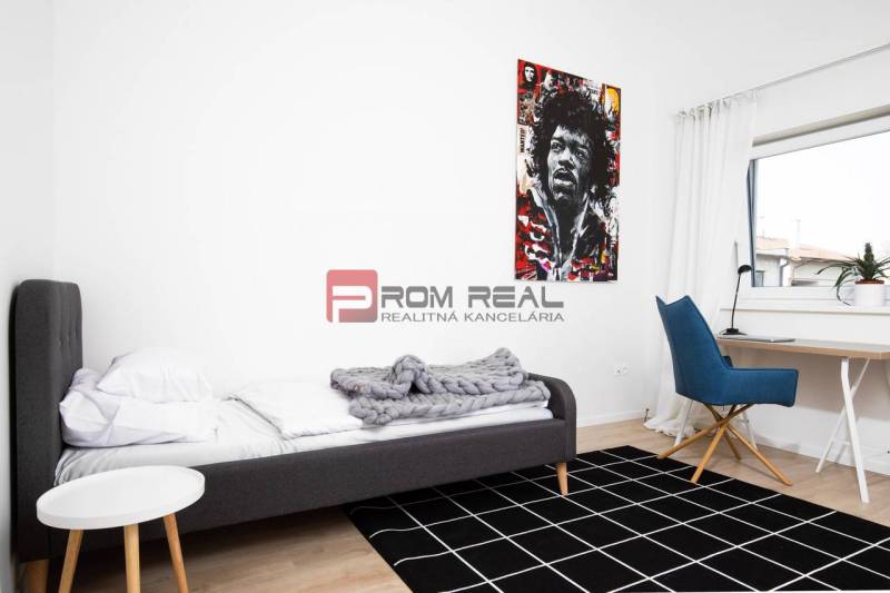 Bedroom in a 3-room apartment with a bed, an armchair, and a picture on the wall.