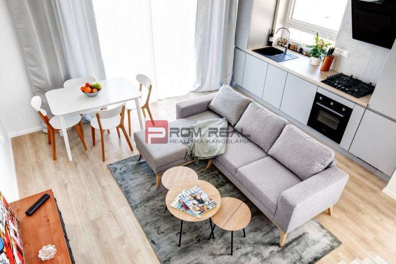 Kitchen and living room in a 3-room apartment with a dining table and a sofa.
