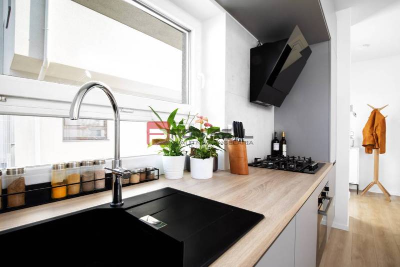 A kitchen in a 3-room apartment with a built-in hob and plants on the windowsill.
