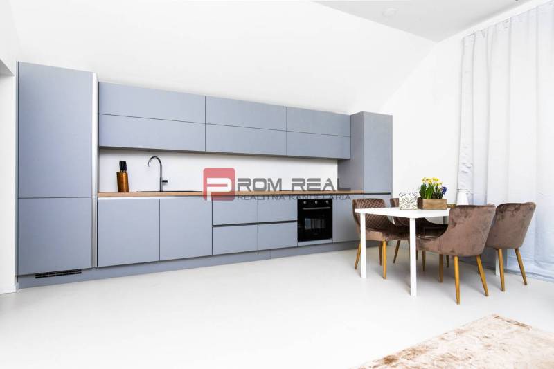 A kitchen in a 3-room apartment with modern furniture and a dining table with three chairs.