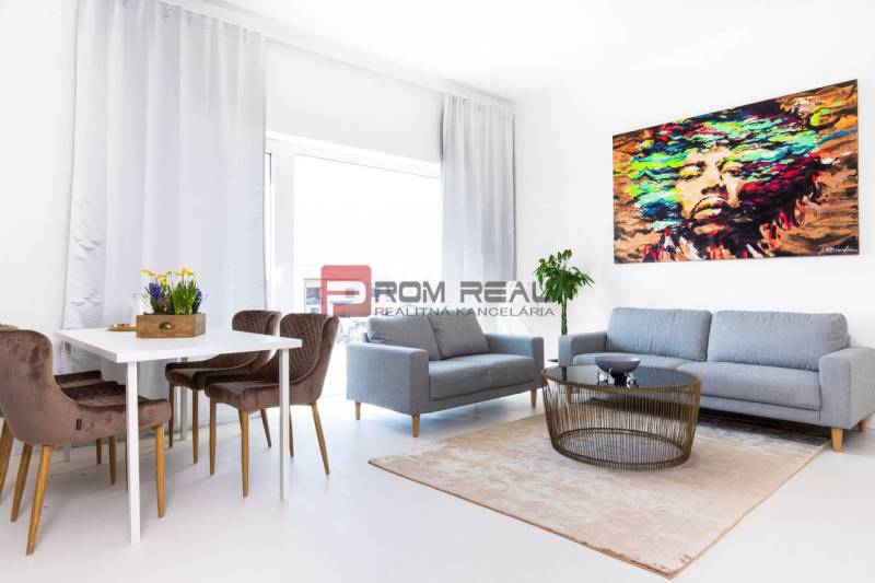A bright living space in a 3-room apartment with a sofa, dining table, and abstract art.