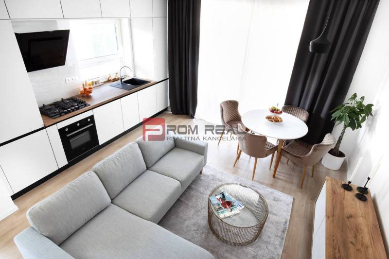 A bright kitchen connected to the living room, a dining nook, and stylish armchairs in a 3-room apartment.