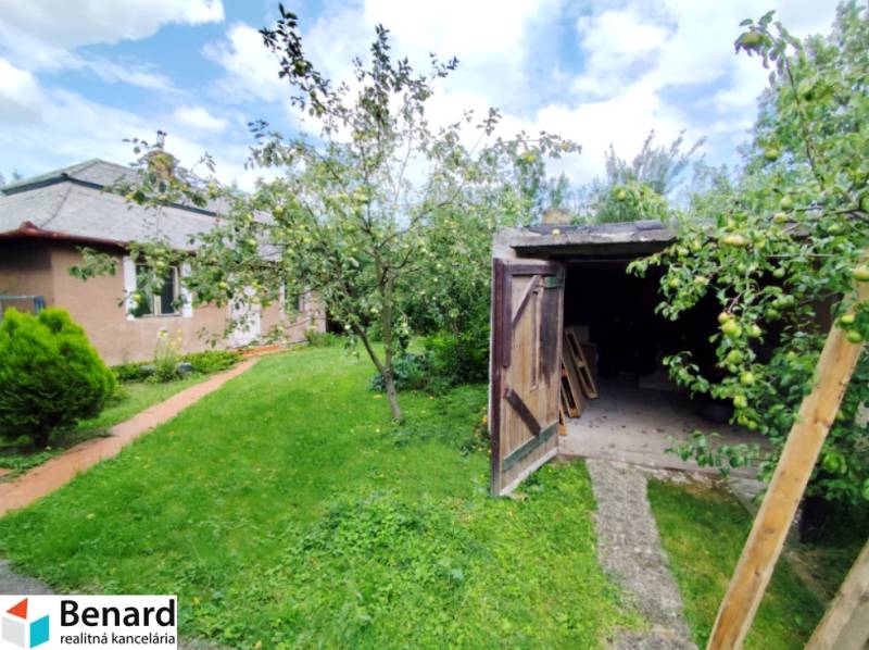 A garden with a lawn and trees at a family house in Veľký Šariš, also includes a woodshed.